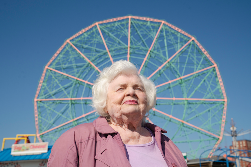 June Squibb as Eleanor Morgenstein, with the Coney Island ferris wheel in the background.